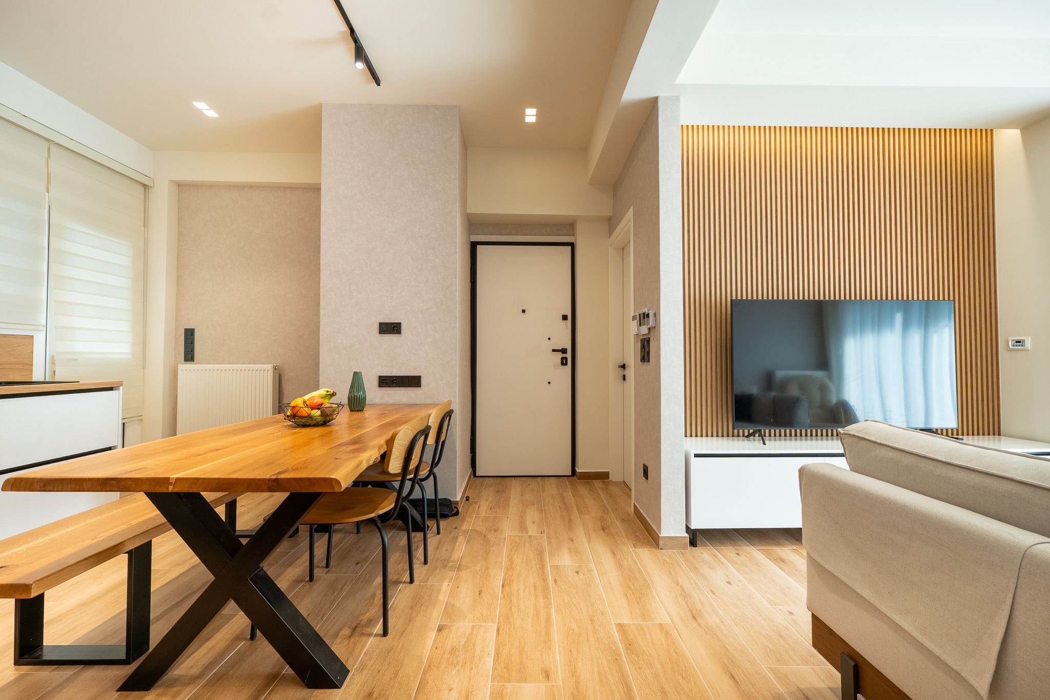 A&K Chorothetisis, dining and entry vista with live-edge table and slatted TV wall