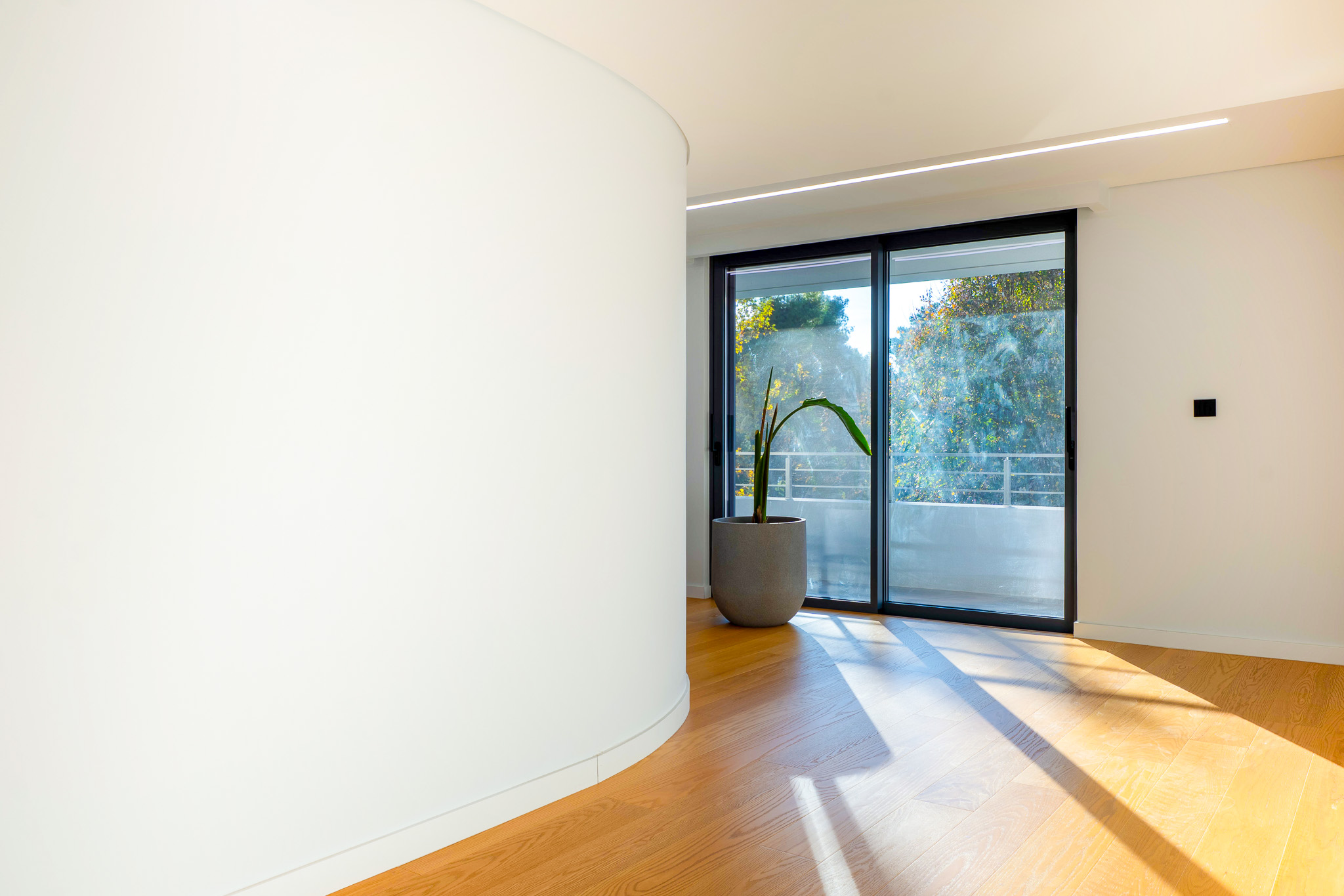 Villa Bond, curved white-wall corridor with sliding doors